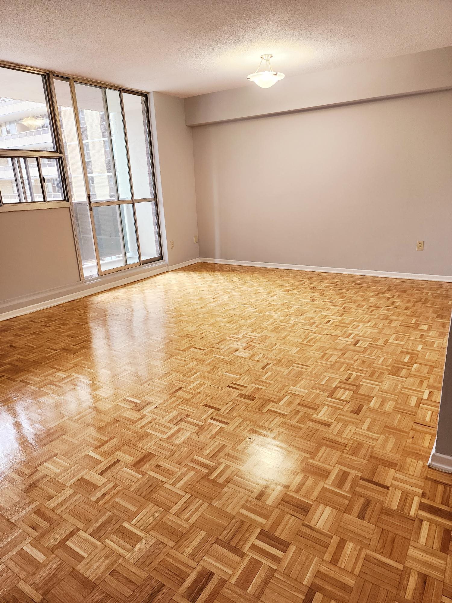 A room with wooden flooring and a window.